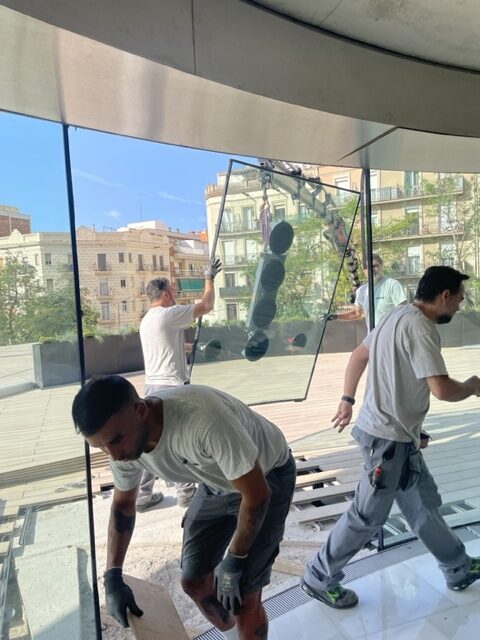 imagen de los trabajadores de talleres alcay instalando un panel de cristal de un ventanal 